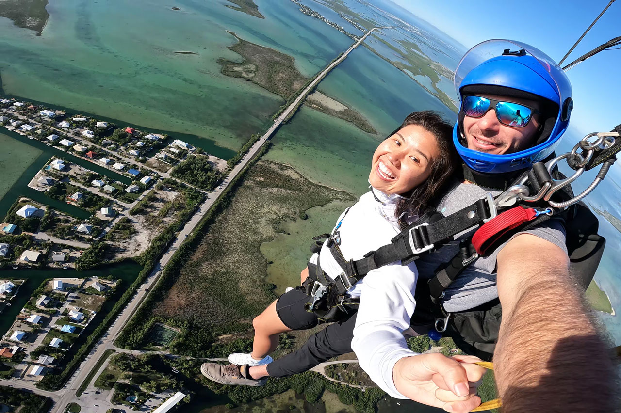 young woman wearing a white shirt enjoys the peaceful canopy ride portion of her Florida Keys Skydiving