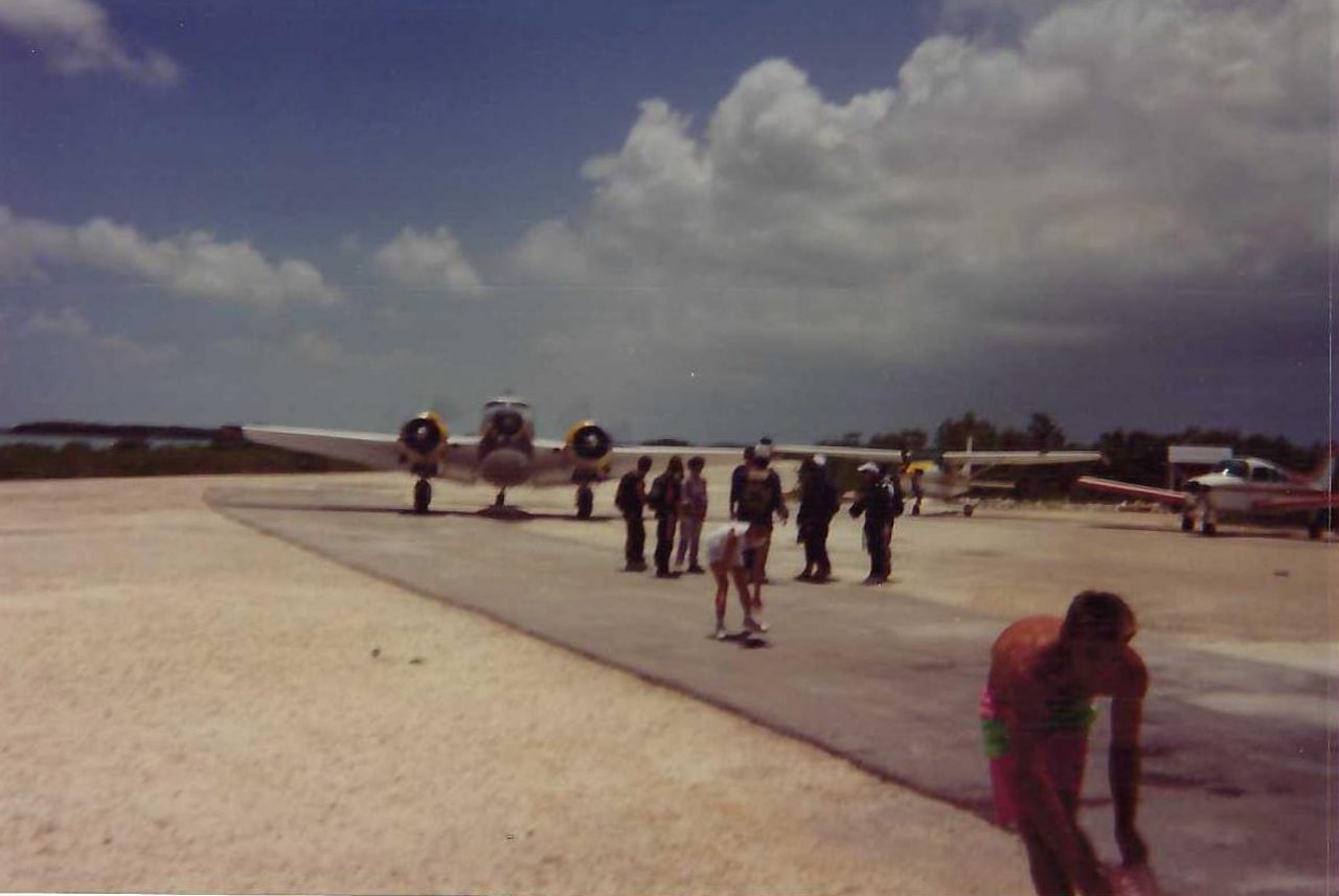 Skydive Key West in the 90's with people standing on runway in front of an airplane