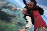 Male and female tandem skydivers over the breathtakingly blue and scenic Florida Keys.