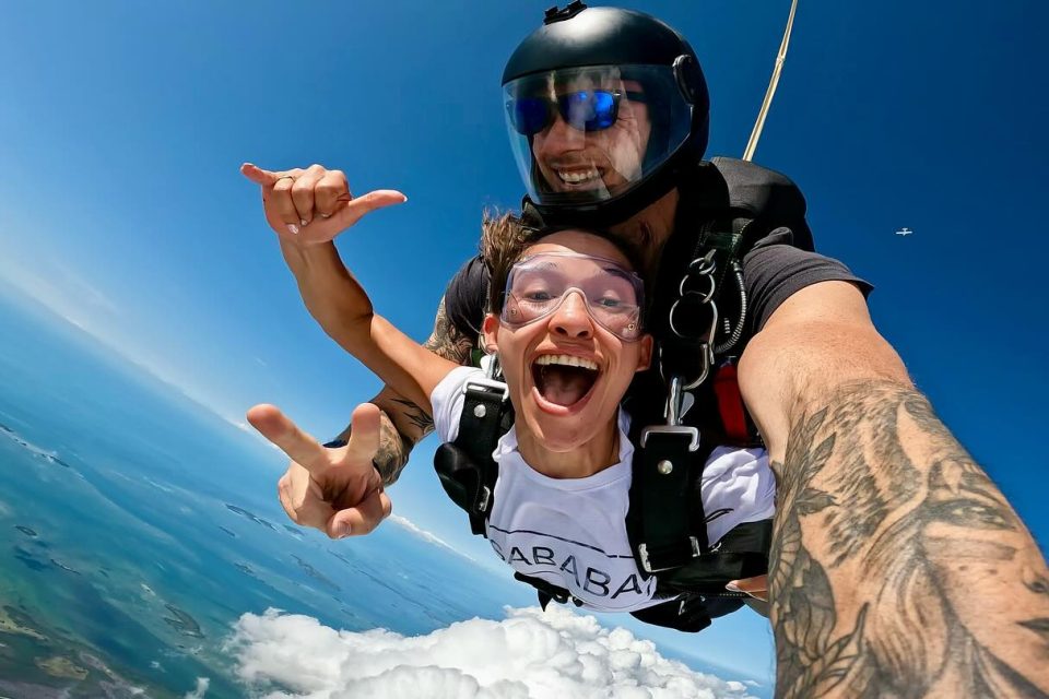 Girl smiling and giving the shakka symbol while in freefall over Key West