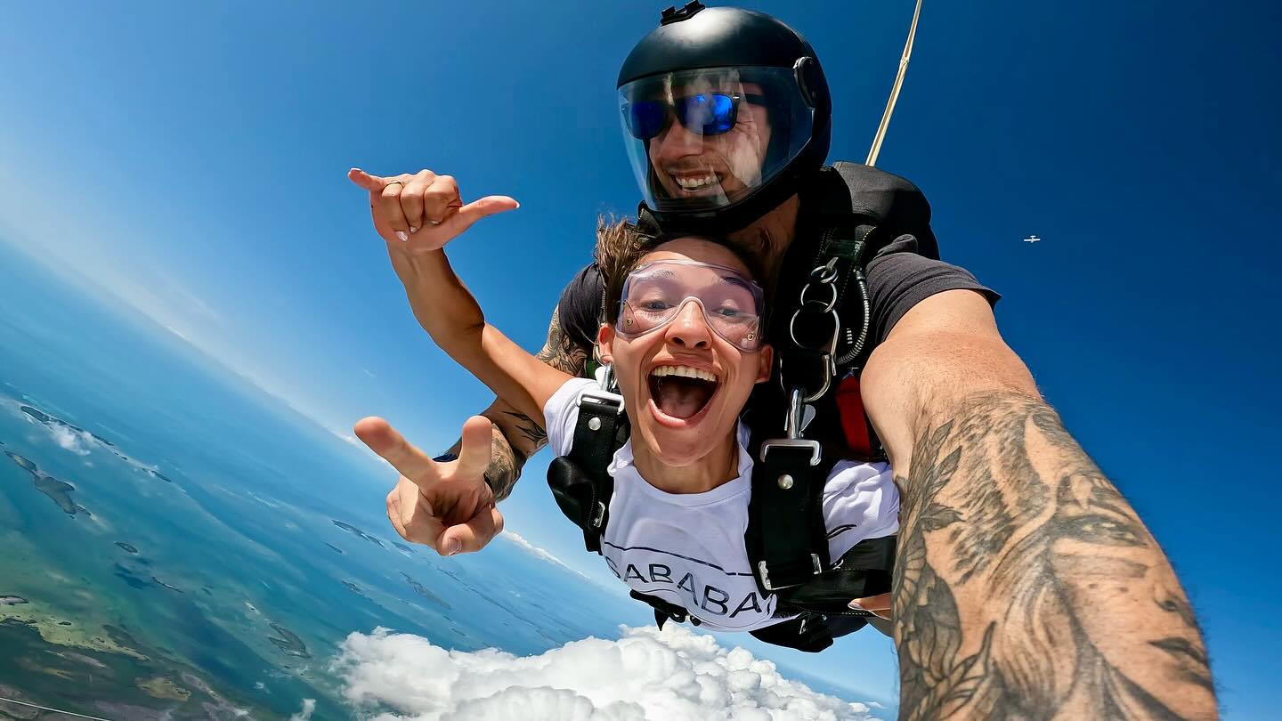 Girl smiling and giving the shakka symbol while in freefall over Key West