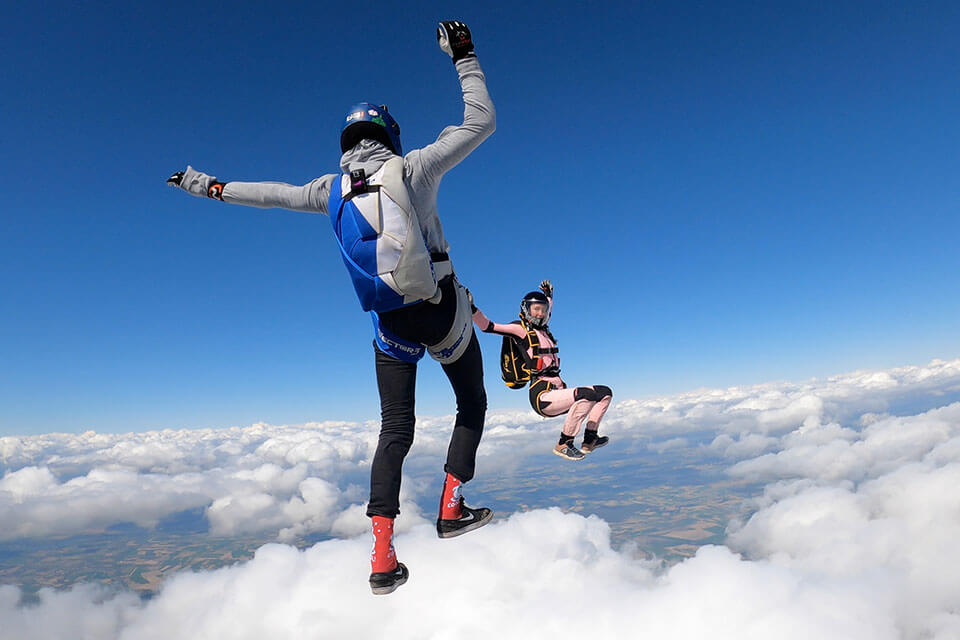 Licensed skydivers freeflying in the standing and seated positions.