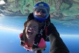Smiling skydiving instructor and female student in freefall