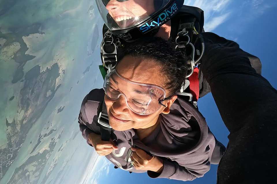 Tandem skydiving student smiling with closed eyes during freefall