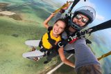 Young female wearing yellow shirt smiles as she enjoys Florida Keys Skydiving