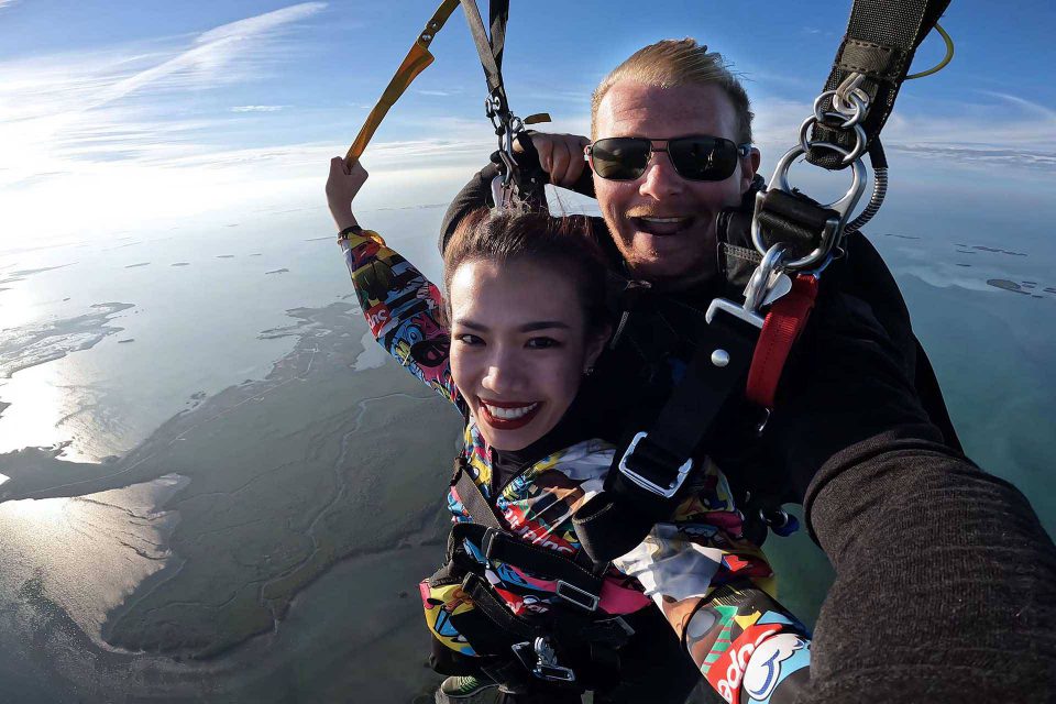 Young woman tandem skydiver smiles during beautiful skydive over the Florida Keys