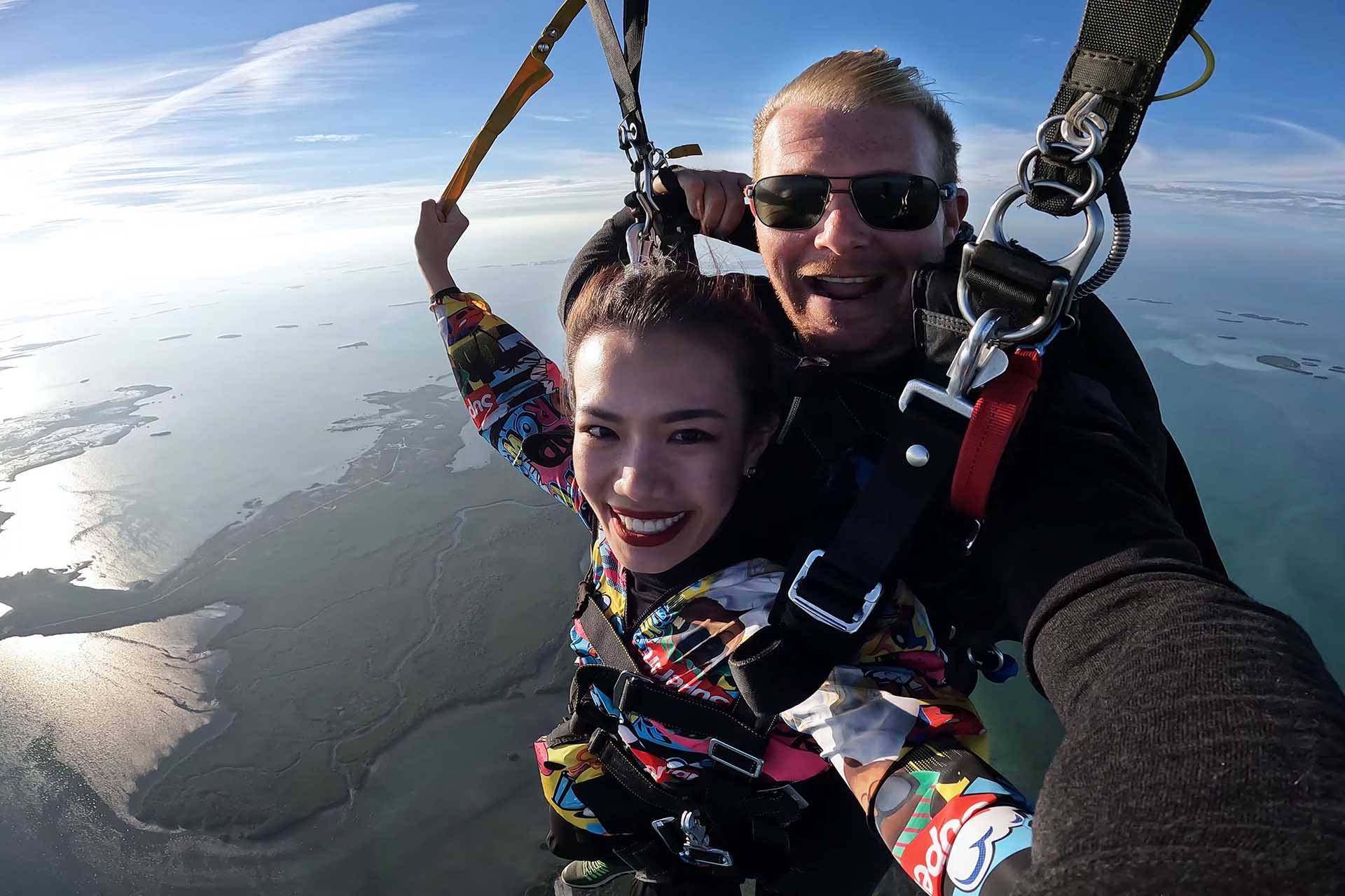 Young woman tandem skydiver smiles during beautiful skydive over the Florida Keys