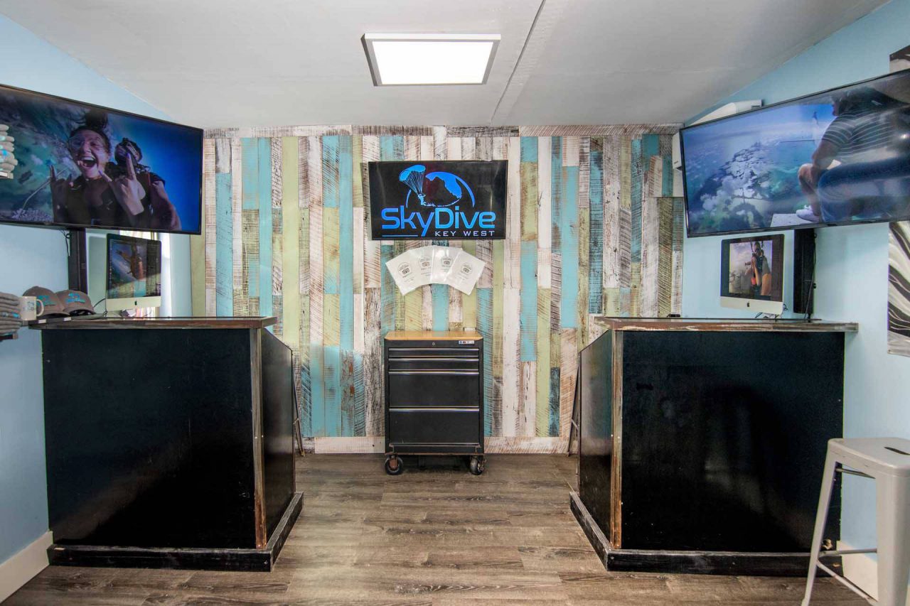 Skydive Key West facilities building with beautiful soft blue walls and viewing tv's hanging on the walls
