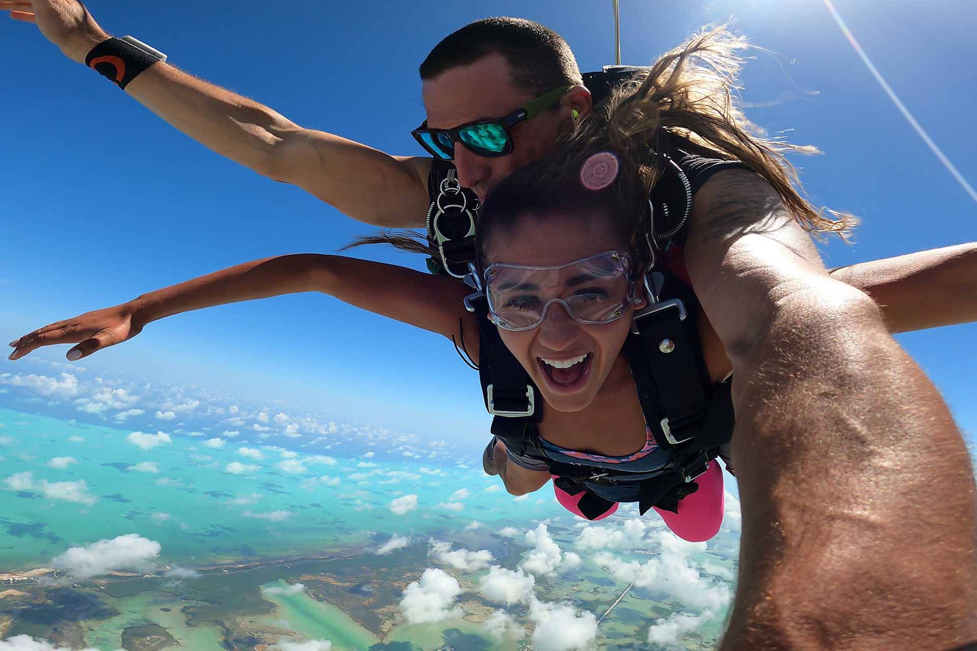 Female tandem skydiving student and instructor in freefall above Skydive Key West