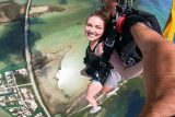 Young female wearing a black tank top enjoys the peaceful canopy portion of her Florida Keys Skydiving