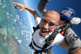 Man wearing white shirt and clear goggles tandem skydiving at Skydive Key West