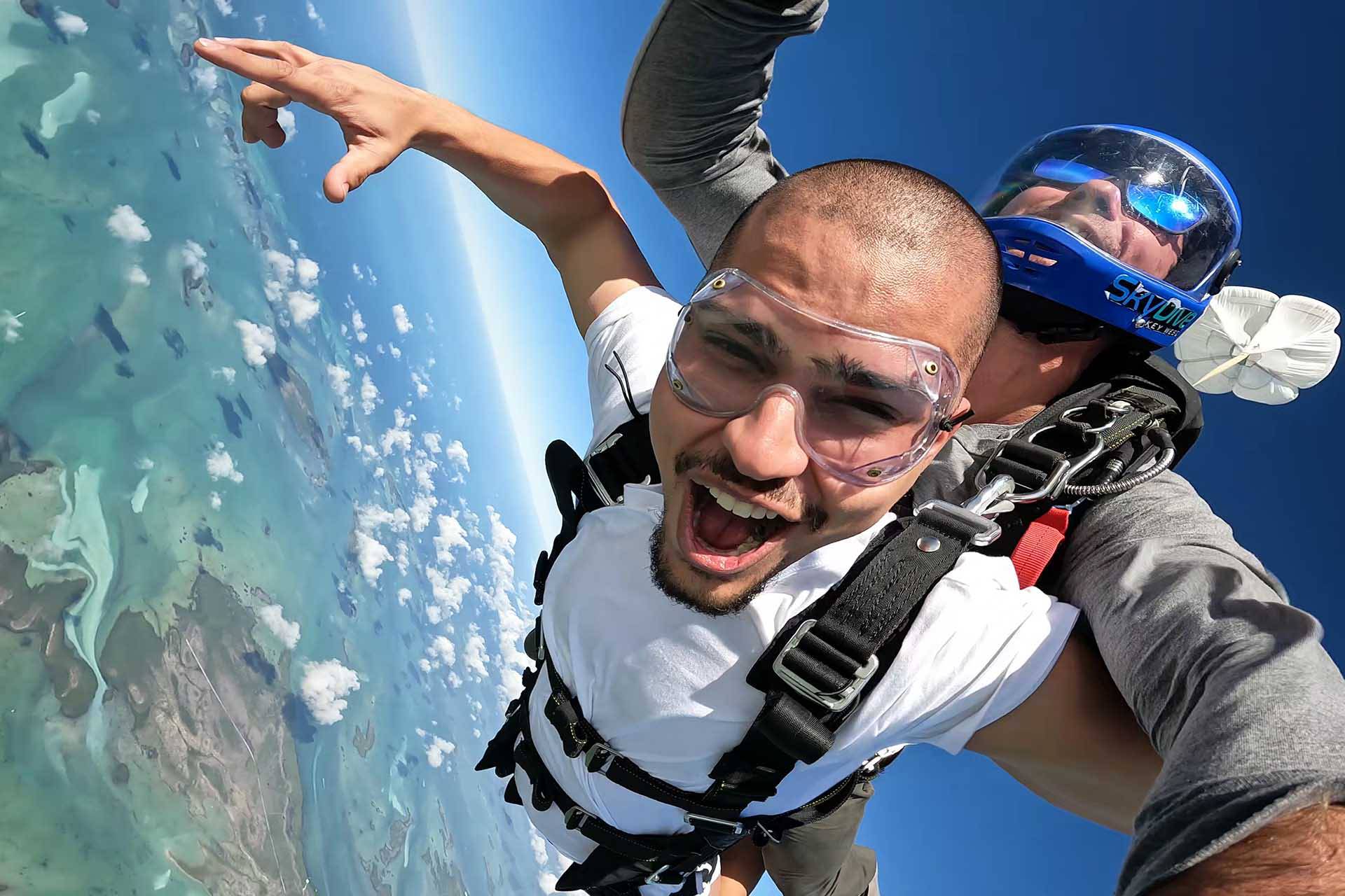 Man wearing white shirt and clear goggles tandem skydiving at Skydive Key West