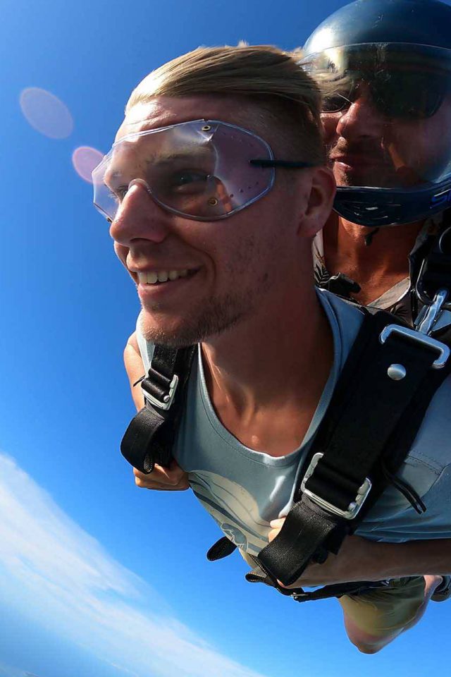Young man wearing blue shirt enjoys Florida Keys Skydivingjoys his