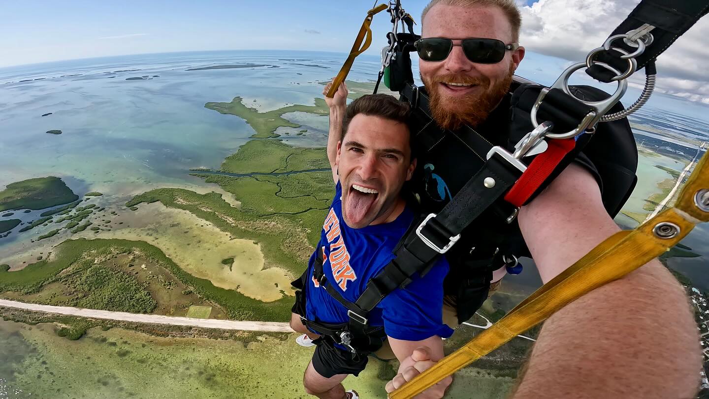 Man skydiving over Key West with his tongue out.