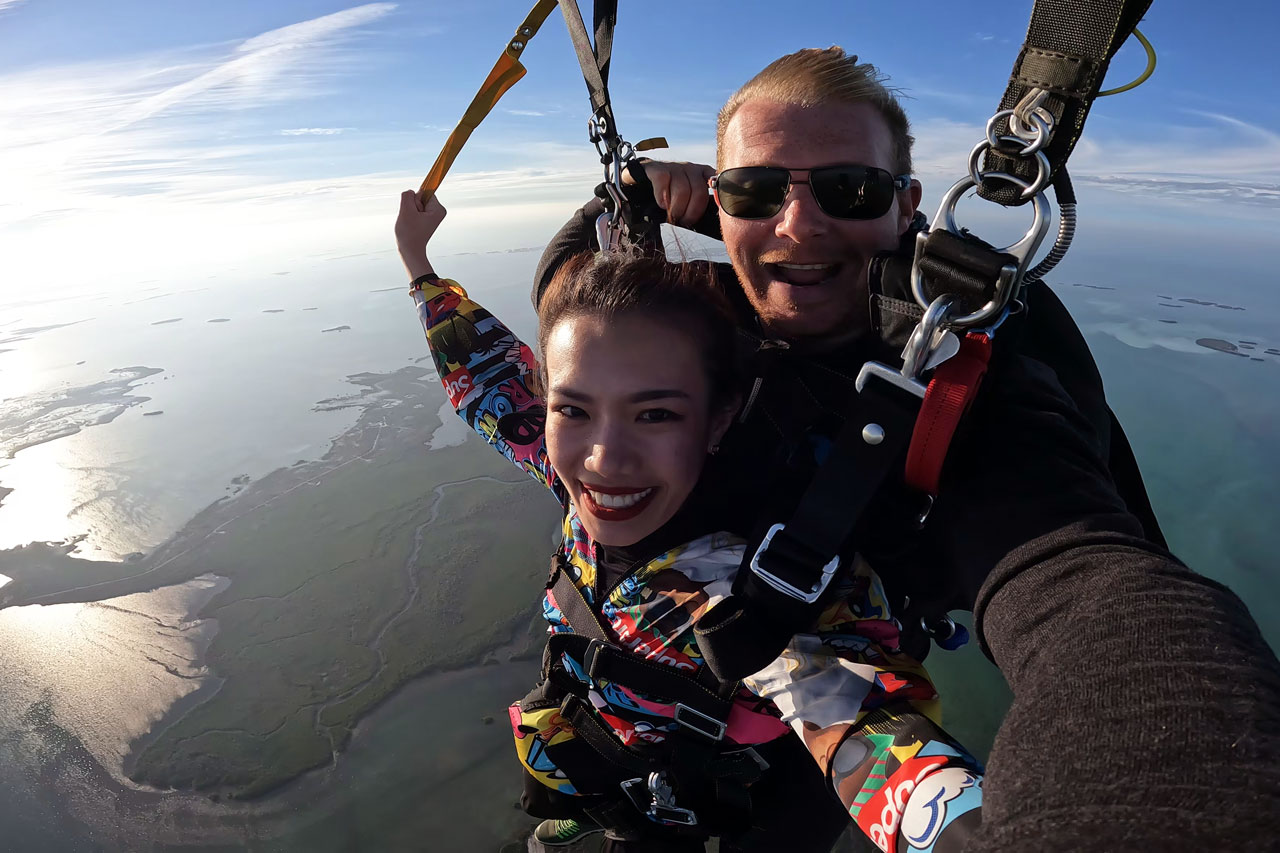 Young woman tandem skydiver smiles during beautiful skydive over the Florida Keys