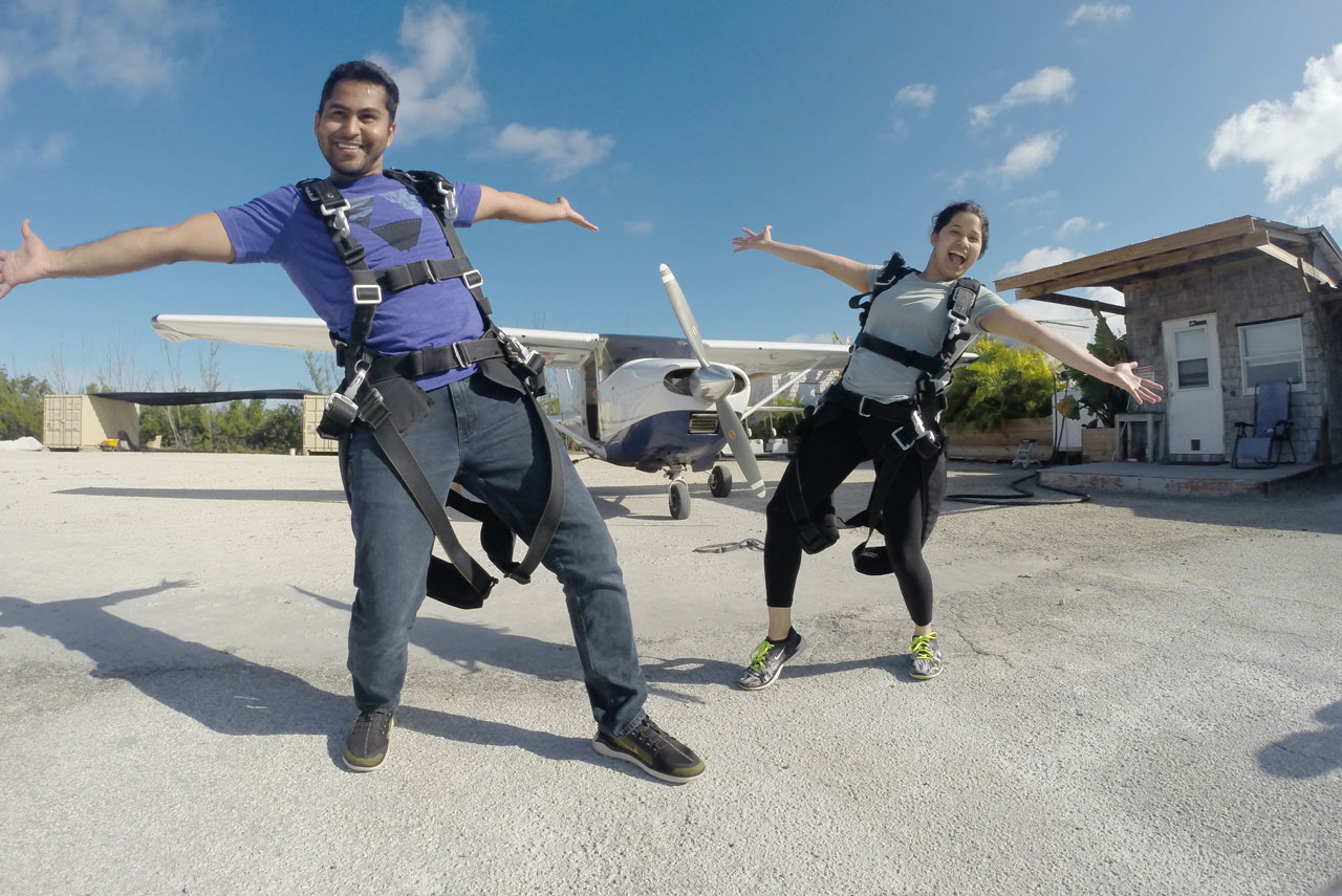 Tandem skydivers pose happily in front of Skydive Key West airplane before enjoying Florida Keys Skydiving